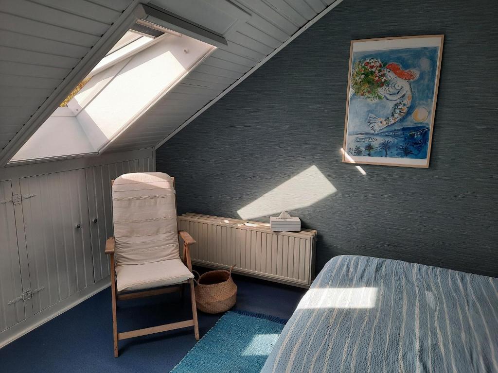 a attic room with a bed and a window at On our way to Antwerp, first stop in Mortsel