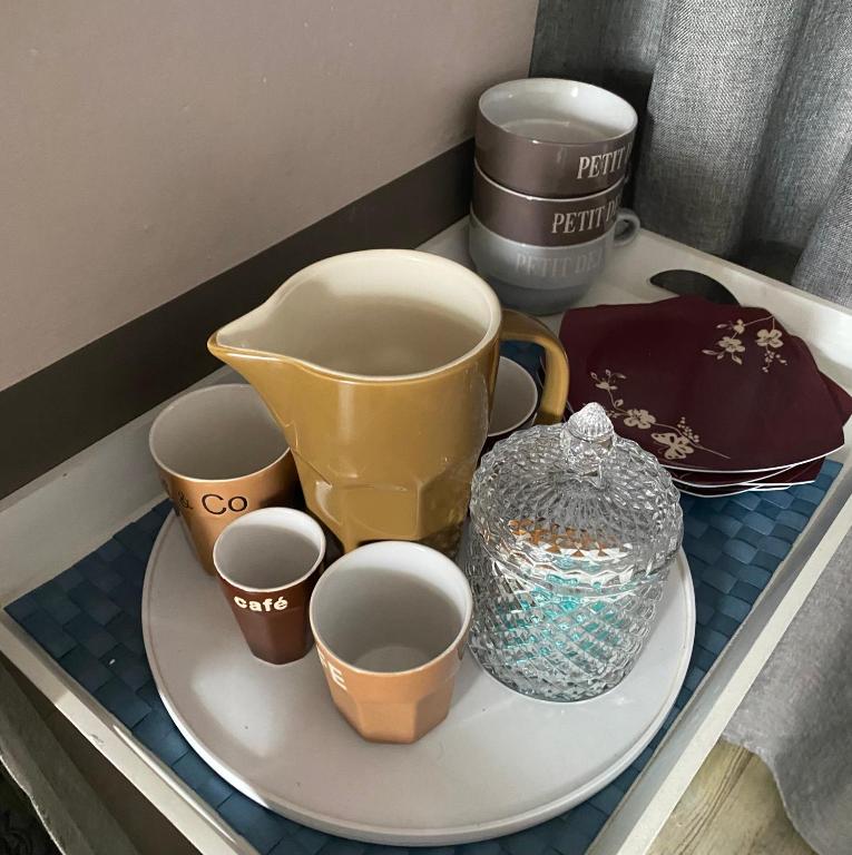 a tray with cups and a tea pot on it at Les Lauriers Duplex centre ville avec jardin in Nyons