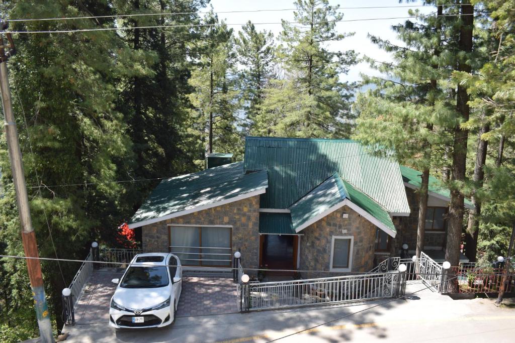 a house with a car parked in front of it at Serenity House in Nathia Gali