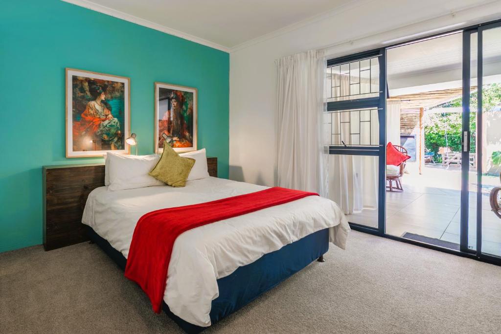 Un dormitorio con una cama con paredes azules y una ventana en Absolute Bosch Guest House, en Stellenbosch