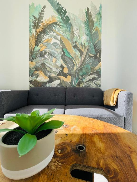 un salon avec un canapé et une table avec une plante dans l'établissement Le Lussaut, à Saint-Jean-dʼAngély