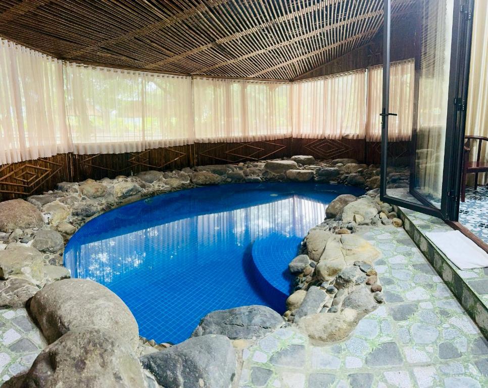 a large swimming pool with rocks around it at Mua Caves Ecolodge (Hang Mua) in Ninh Binh