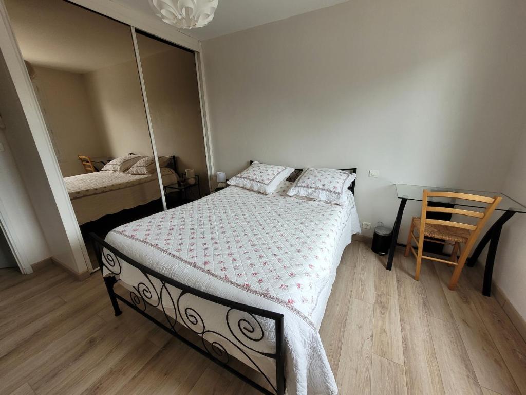 um quarto com uma cama e uma cadeira em Appartement Le Pontet em Avignon