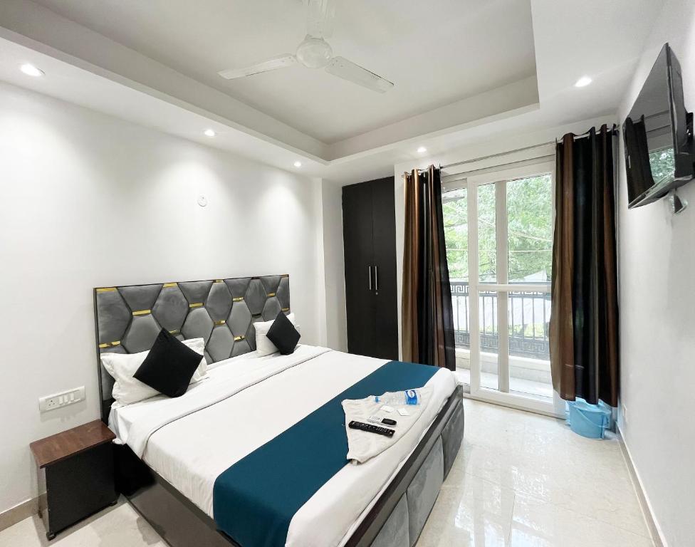 a bedroom with a large bed and a television at Hotel 24 Seven - Malviya Nagar in New Delhi