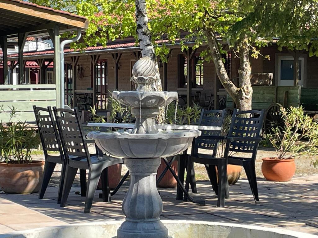 einen Brunnen vor einem Tisch und Stühlen in der Unterkunft Old West Ranch "Urlaub auch mit Pferd möglich" in Windelsbach