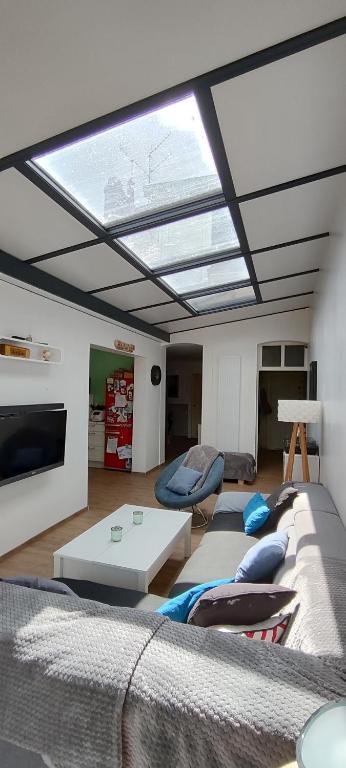 un salon avec une grande lucarne au plafond dans l'établissement 7 min du circuit des 24 h du Mans et 10 min de la Gare - LA BERTINIERE, au Mans