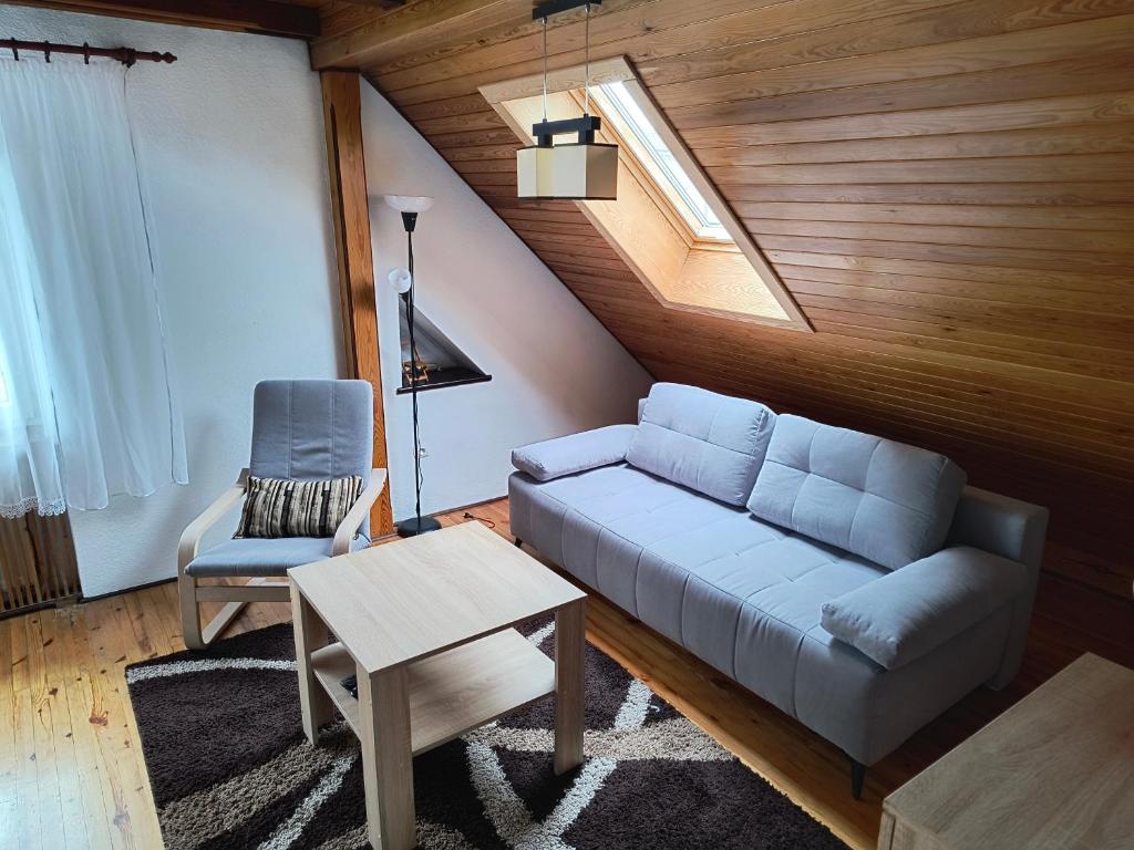 a living room with a couch and a chair at Apartament Pod Orzechem in Augustów
