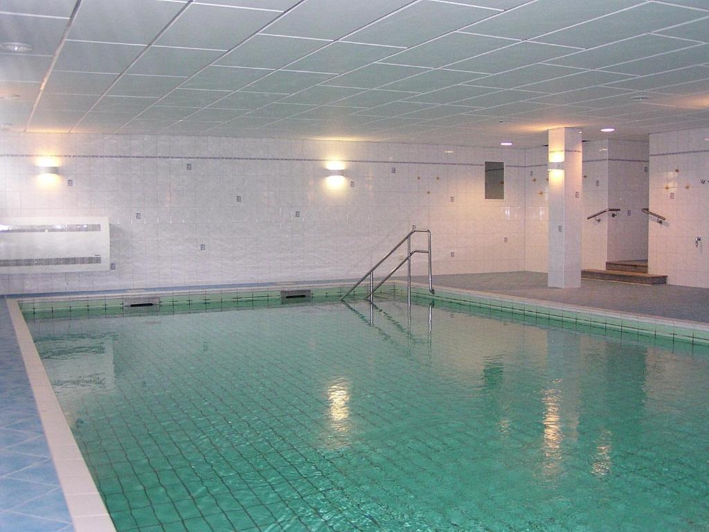 einen großen Pool mit grünem Fliesenboden in der Unterkunft Wellness-Ferienwohnung Strandperle in Cuxhaven