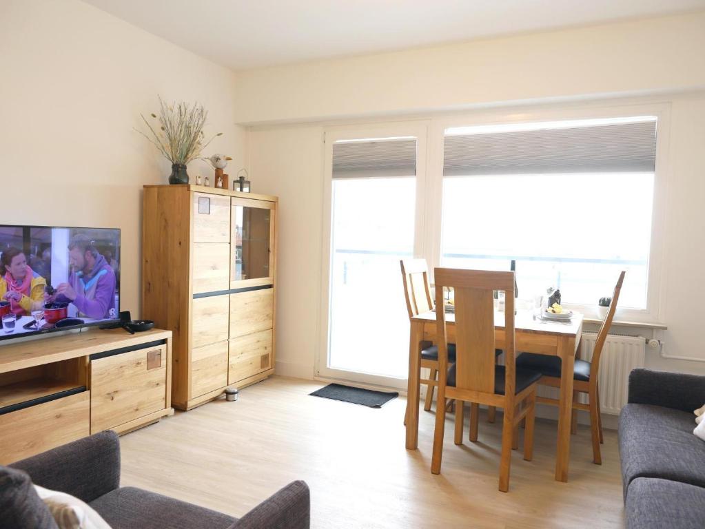 a living room with a television and a dining room table at Einfaches 2-Zimmer-Appartement mit Balkon. in Westerland