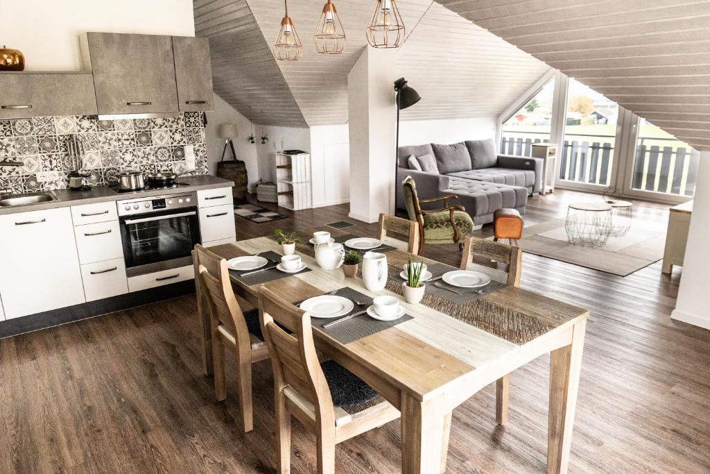 a kitchen and living room with a wooden table and chairs at Ferienwohnung Fichtelblick in Schönwald