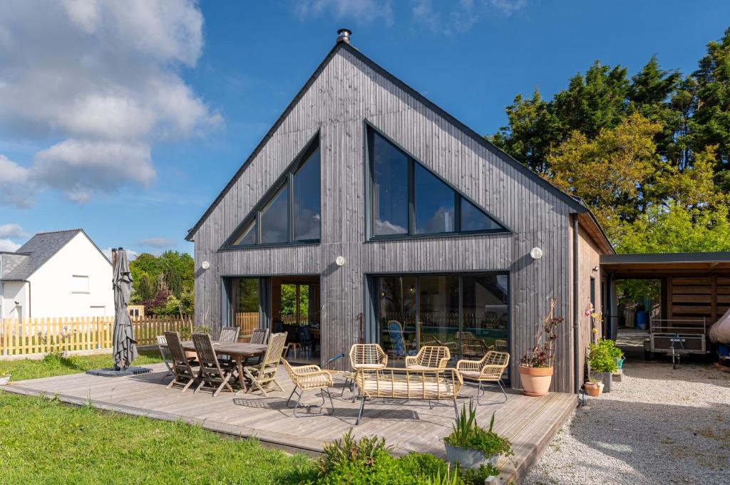 ein Haus im Scheunenstil mit Glasfenstern und einer Terrasse in der Unterkunft Gite ty laouen in Sarzeau