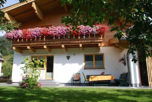 ein Haus mit einem Balkon mit Blumen darauf in der Unterkunft Wagnerhäusl in Bramberg am Wildkogel