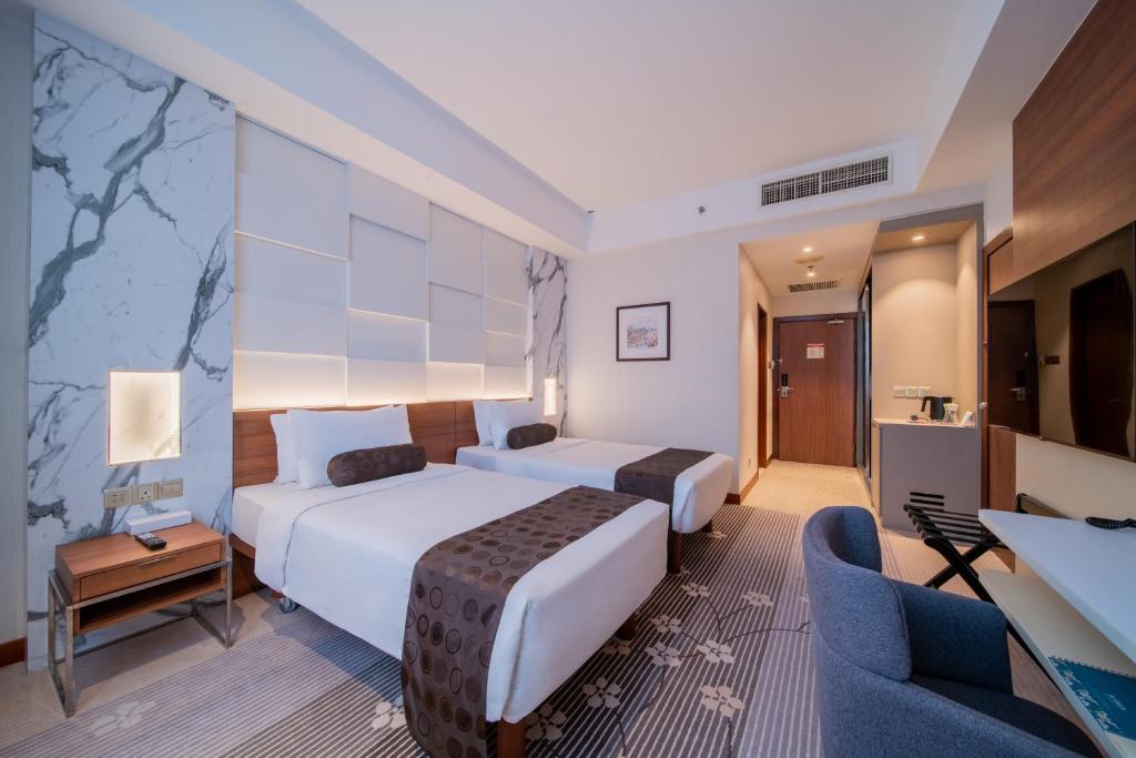 A twin room with two beds, a compact desk and a television.