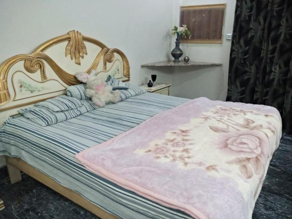 una cama con un osito de peluche sentado encima en Chand Bibi Hotel en Peshawar