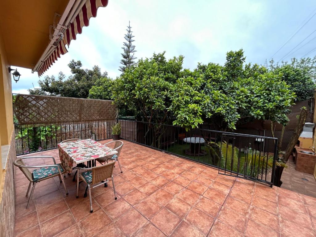 un patio con mesa, sillas y una valla en La casa de los naranjos, en Vega de San Mateo