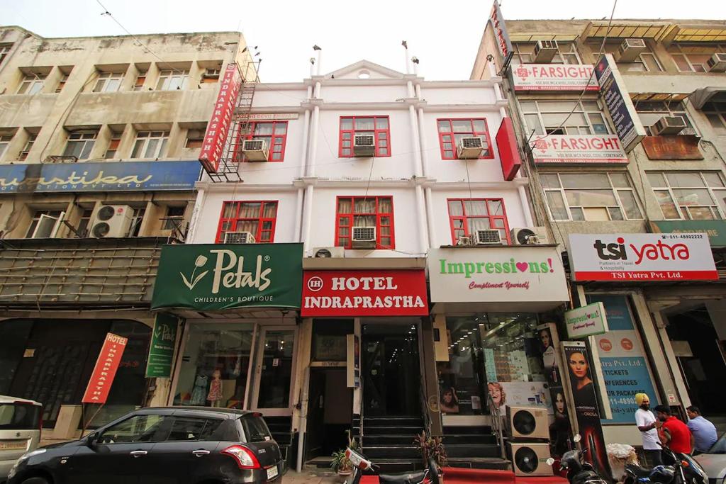 un edificio en una calle de la ciudad con tiendas en Hotel Indraprastha, en Nueva Delhi