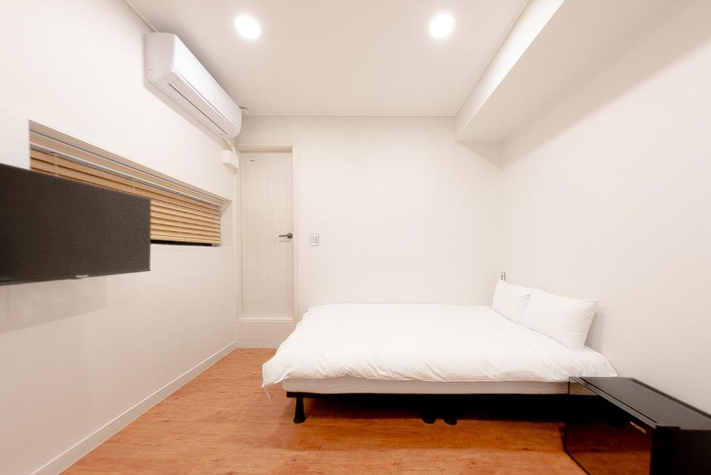 a bedroom with a bed and a flat screen tv at Dawoo House 2 in Hongdae in Seoul