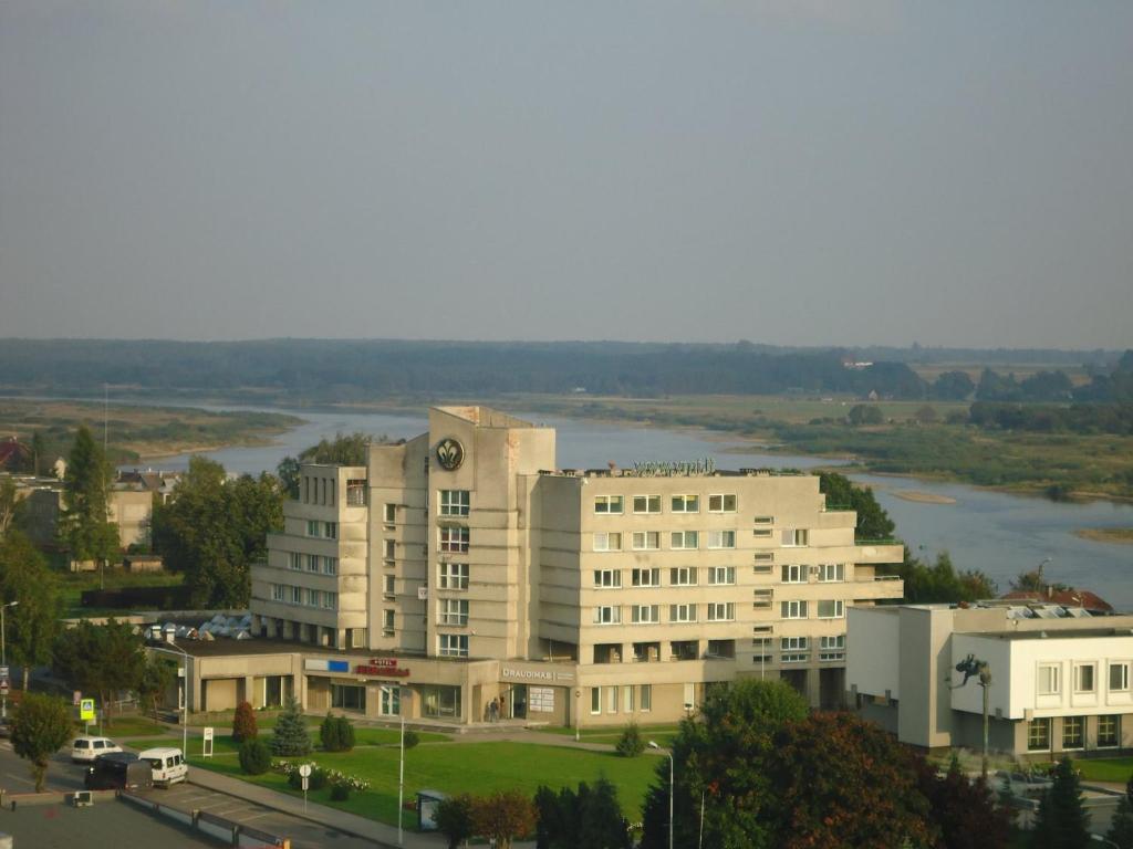 um edifício com um relógio na lateral em viešbutis Jurbarkas em Jurbarkas