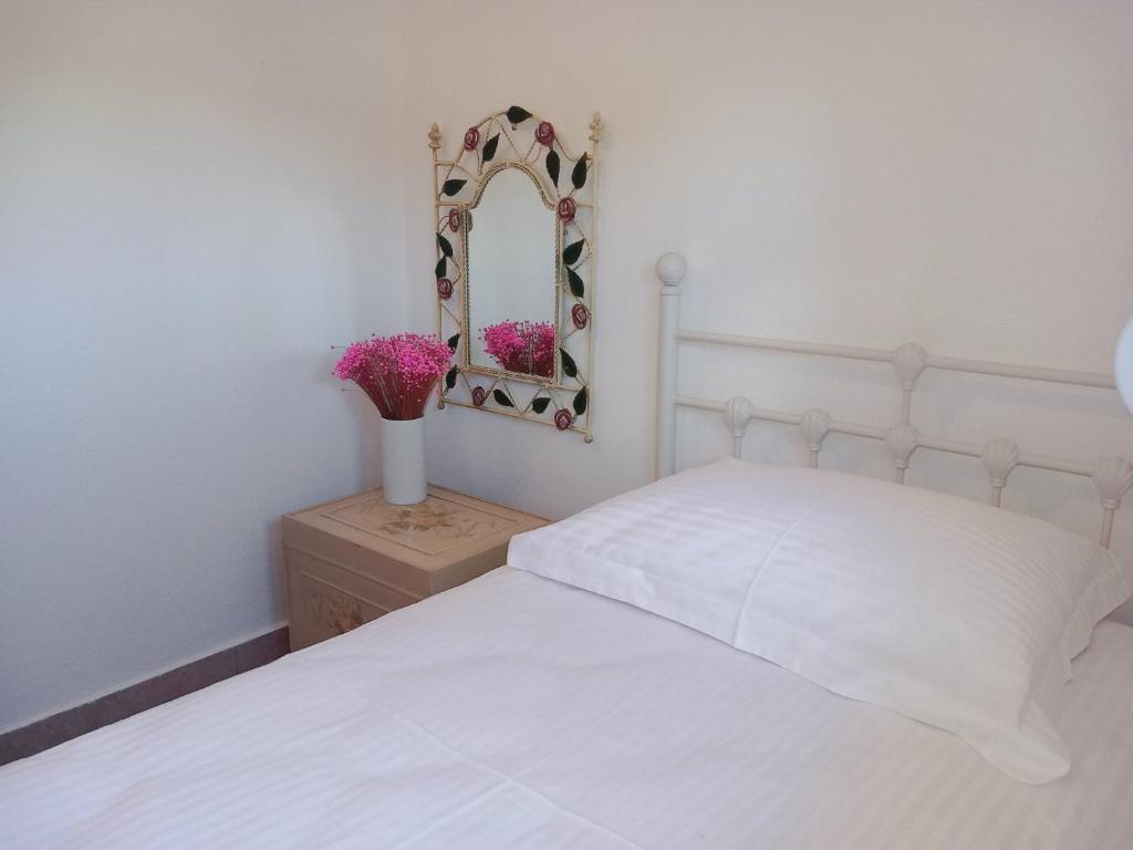 a bedroom with a white bed and a mirror at Olympian Chalet in Paralia Katerinis