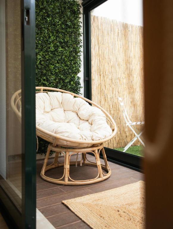 a wicker chair sitting in front of a window at Beira Mar Sunny Patio in Aveiro
