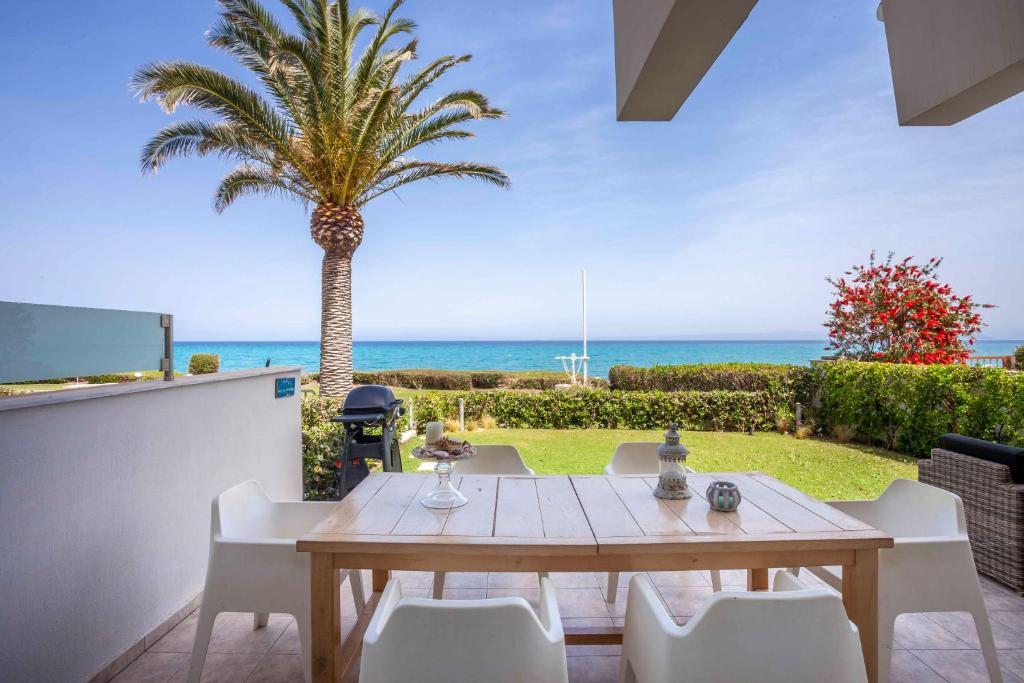 a dining room with a table and a palm tree at Seapalm House in Hanioti