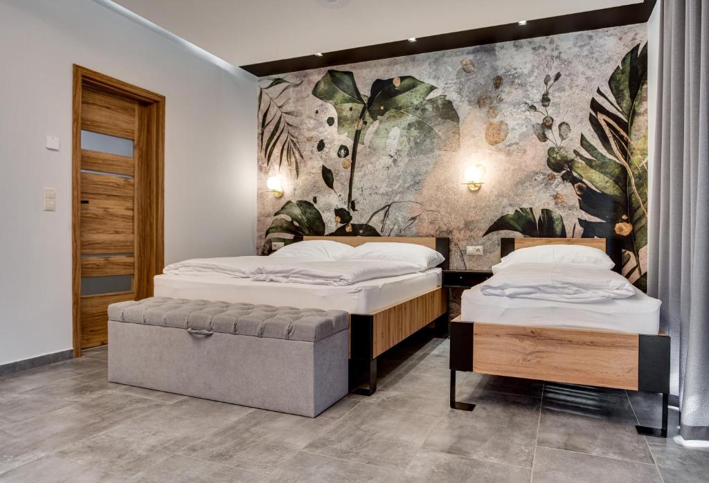 2 camas en una habitación con un mural en la pared en Chillout House en Sótony