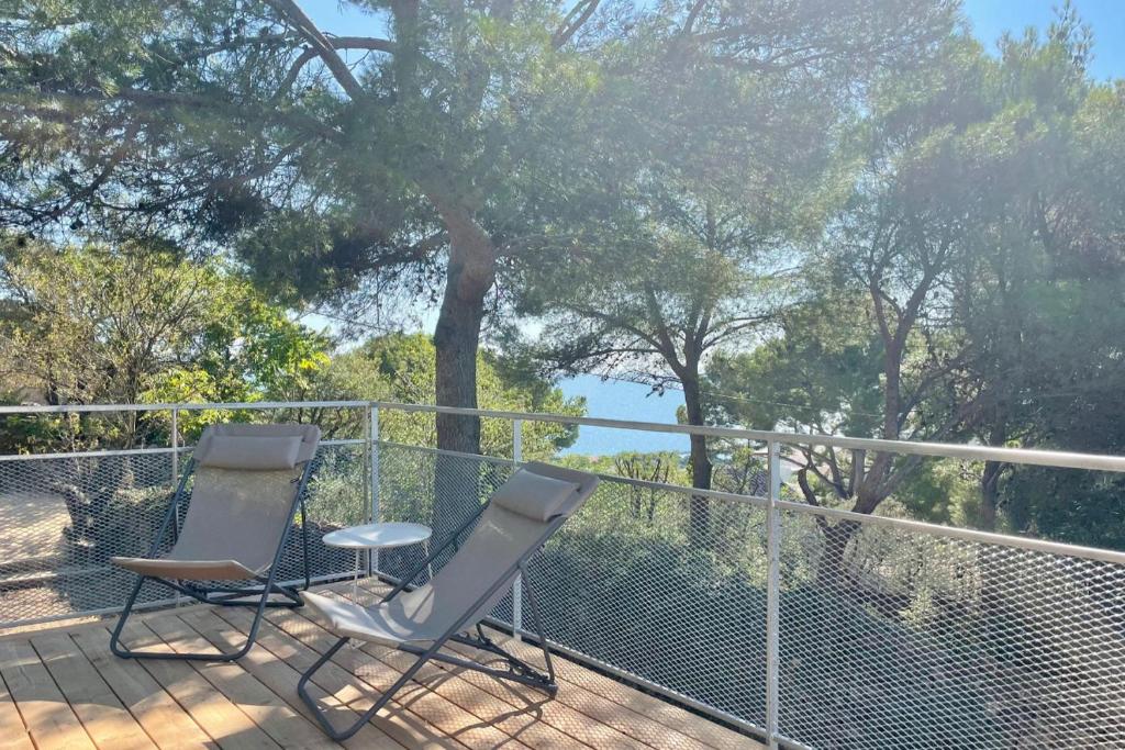 due sedie sedute su un ponte con alberi sullo sfondo di Sète - Maison entière et jardin sur le Mont Saint Clair - vue mer et étang a Sète
