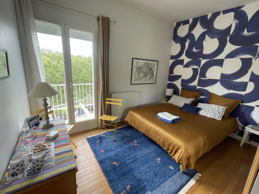 1 dormitorio con cama y ventana grande en Chambre d'hôte Bords de Garonne, en Burdeos