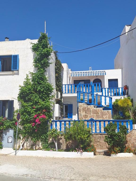 ein Gebäude mit blauen Balkonen und einem Gebäude mit einem Baum in der Unterkunft Marena 2 in Makry Gialos