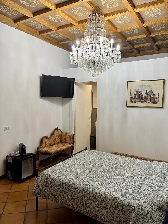 1 dormitorio con lámpara de araña, mesa y silla en Domus Giovanna en Roma