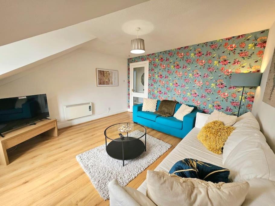 een woonkamer met een blauwe bank en een tv bij Sensational Stay at South Bridge in Edinburgh
