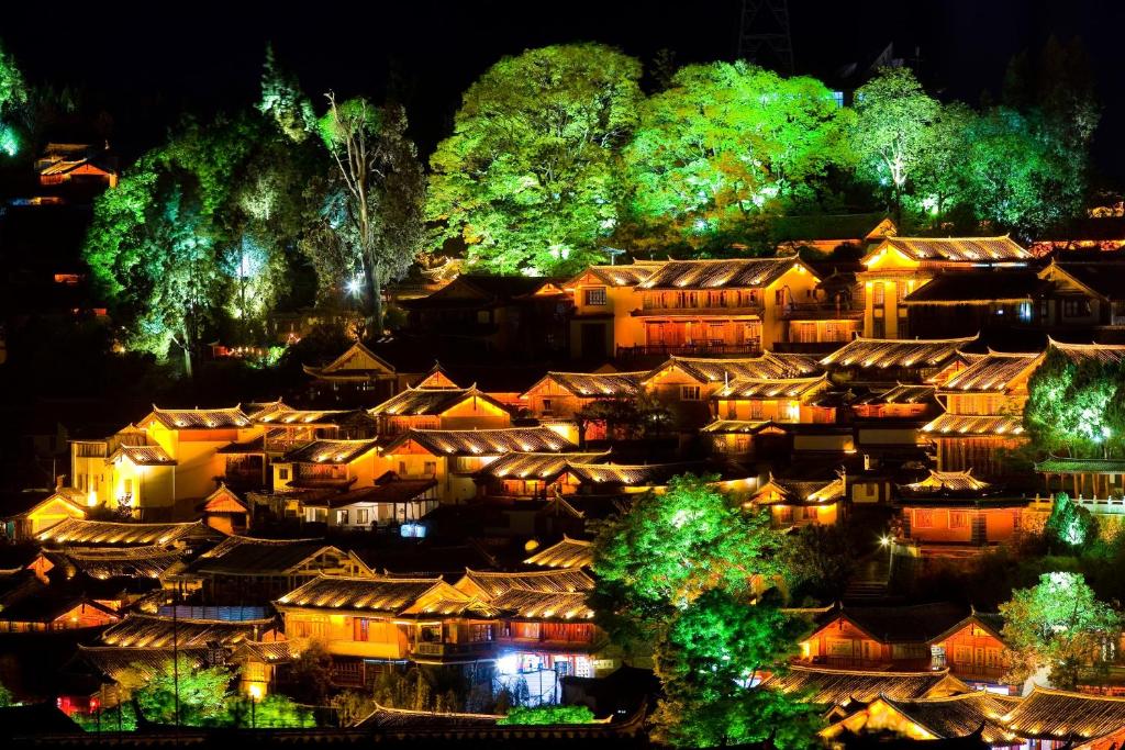 un groupe de maisons dans un village la nuit dans l'établissement 思法特观景客栈 Sifat Viewing Inn, à Lijiang