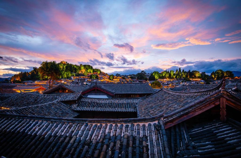 un edificio antiguo con una puesta de sol en el fondo en 思法特观景客栈 Sifat Viewing Inn, en Lijiang