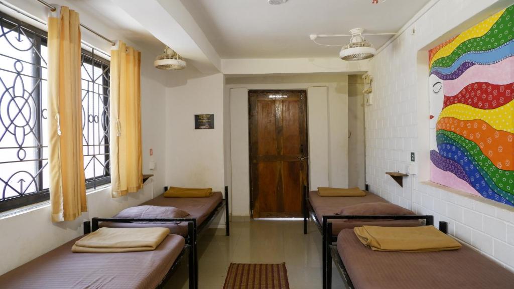 a row of benches in a room with windows at BunkNBrew in Palolem