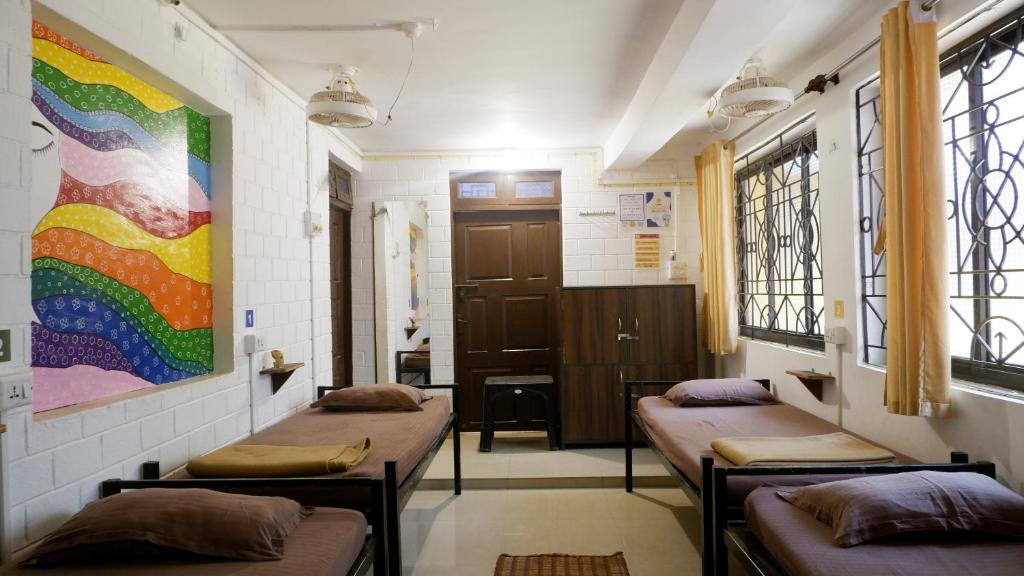 a waiting room with three beds in a room at BunkNBrew in Palolem