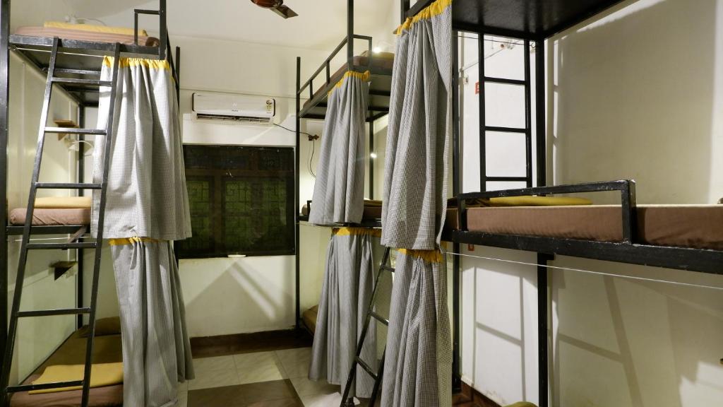 a room with bunk beds in a dorm room at BunkNBrew in Palolem