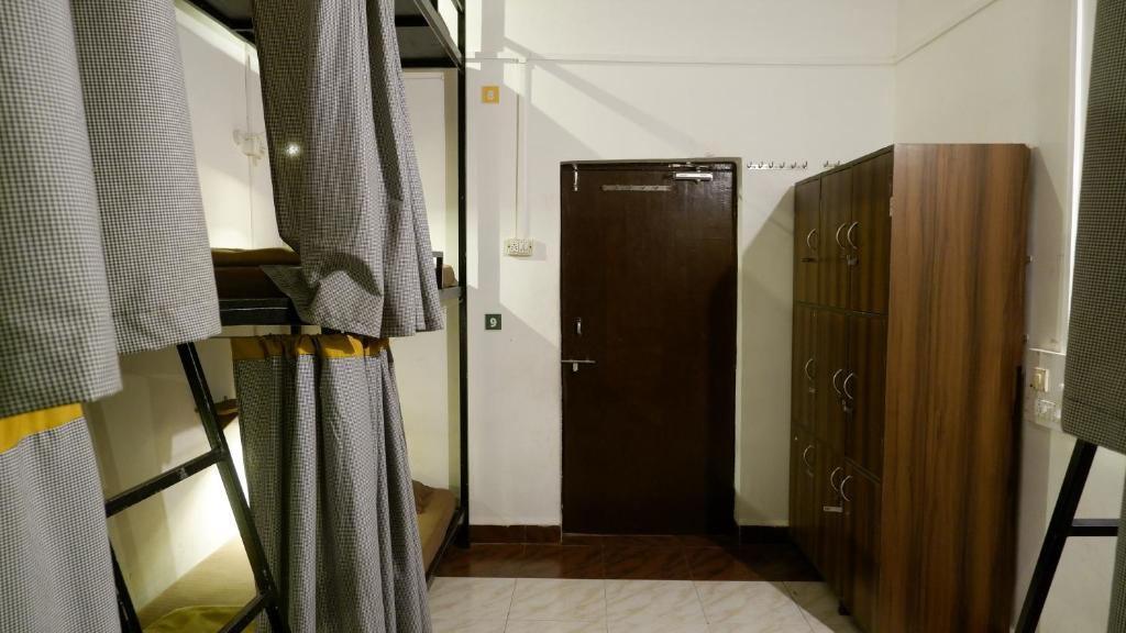 a room with a closet and a door in a room at BunkNBrew in Palolem