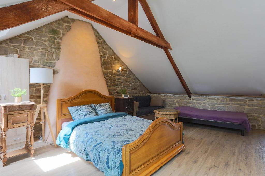 - une chambre avec un lit et un mur en pierre dans l'établissement Gite Relax a la Campagne, à Guern