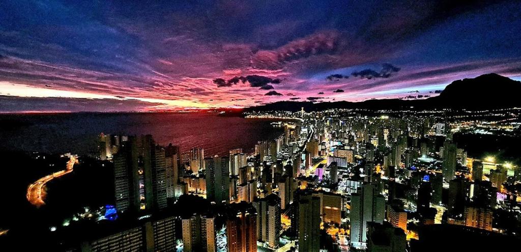 - une vue sur la ville la nuit avec un coucher de soleil dans l'établissement Torre Lugano by Renthas, à Benidorm