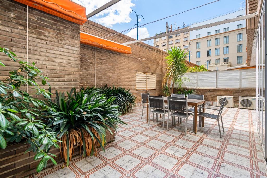 a patio with a table and chairs and plants at Sunlit Expansive Terrace, Ac & Outdoor Seating in Barcelona