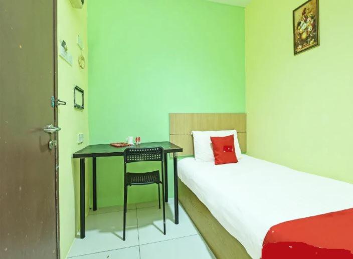 Zimmer mit einem Bett, einem Tisch und einem Stuhl in der Unterkunft South City Hotel @ Bandar Mahkota Cheras in Kuala Lumpur