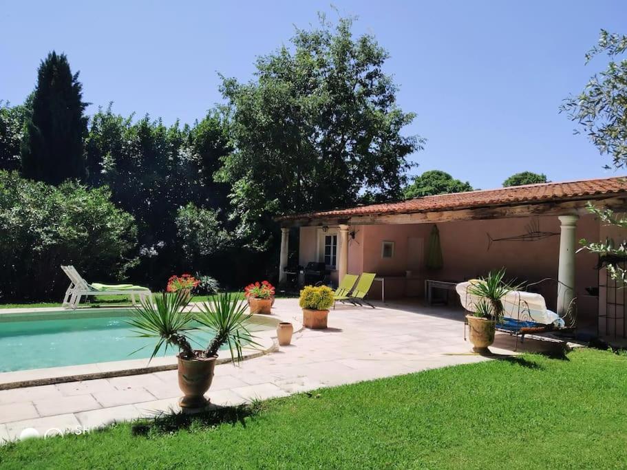 um quintal com uma piscina e uma casa em Domaine avec Piscine em Grans
