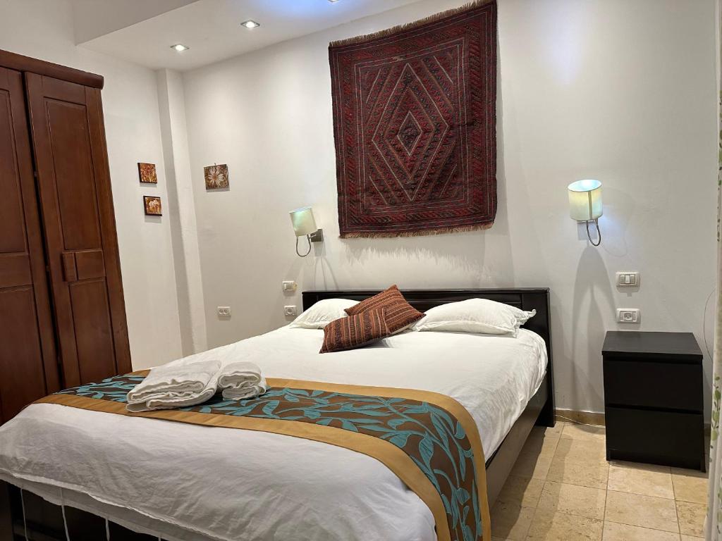 a bedroom with a bed and a picture on the wall at Baka Bauhaus Studio in Jerusalem