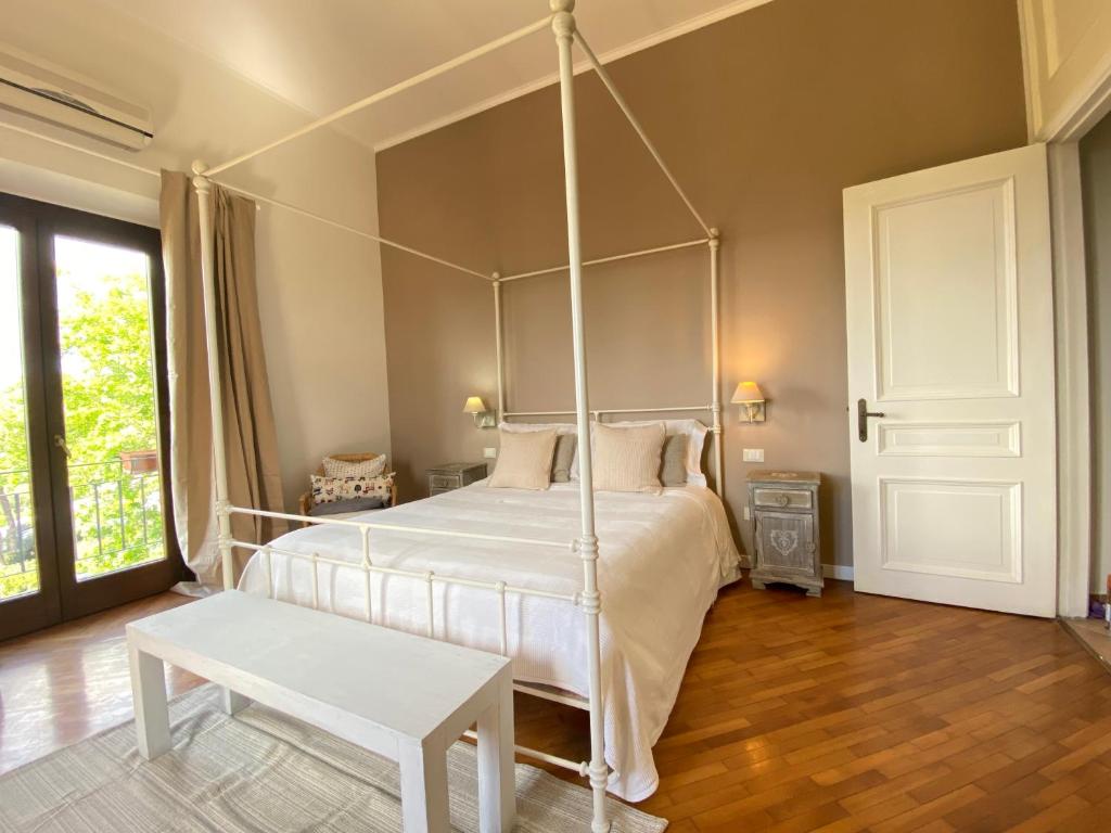 a bedroom with a white canopy bed with a table at “Casa Amélie” in Grottaferrata