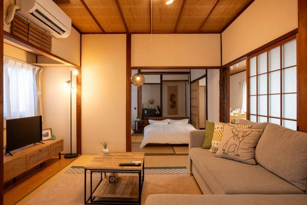 a living room with a couch and a bed at 広島駅北口 古民家House 一軒家貸切り 自転車2台レンタル無料 in Hiroshima