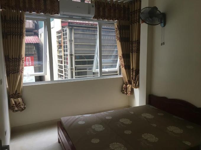 una camera con un letto di fronte a una finestra di Nhà nghỉ Năm Thanh a Hanoi