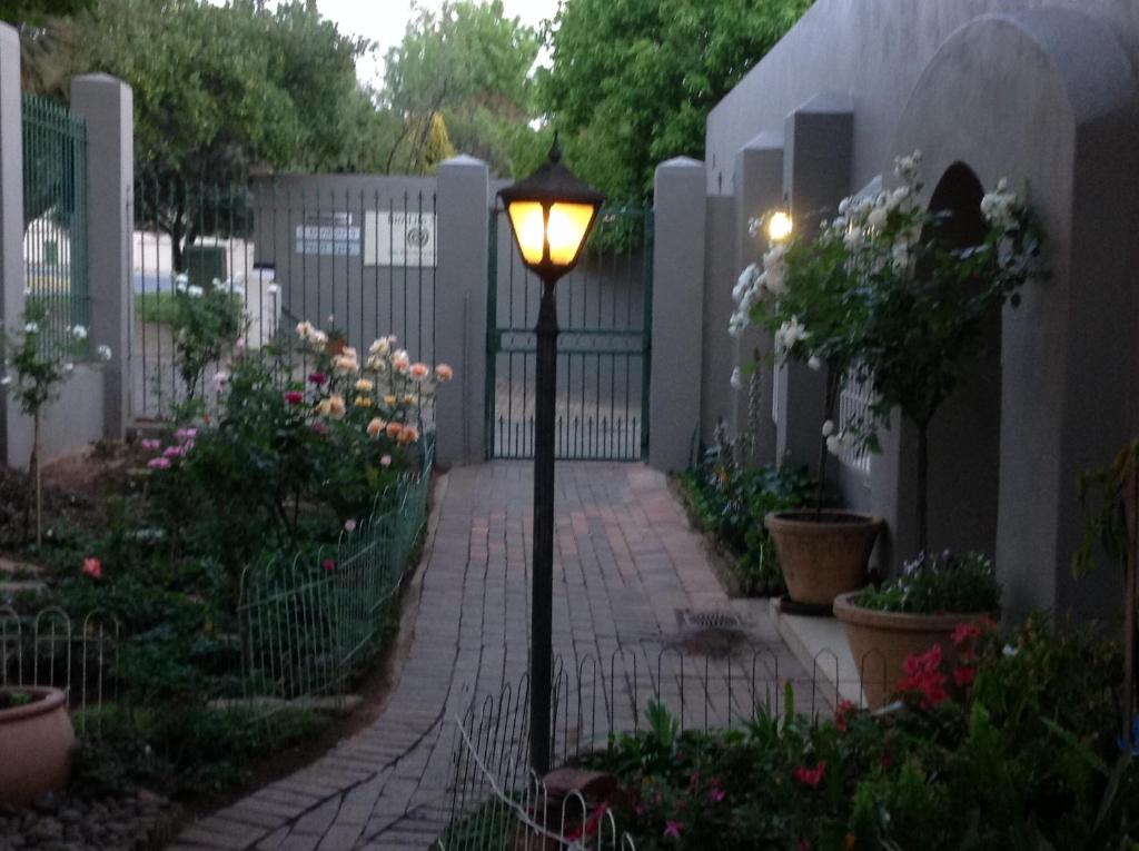 a street light in a garden with a fence at Bio-Pointment Guest Suites in Johannesburg