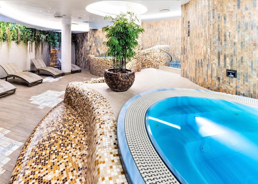 ein großer Pool mit Pflanze in einem Zimmer in der Unterkunft Wellton Riga Hotel & SPA in Riga