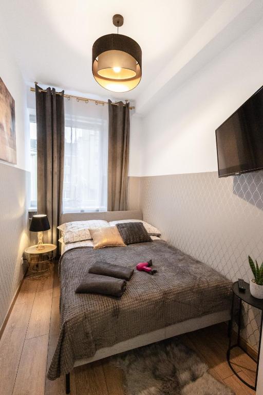 1 dormitorio con 1 cama grande y TV de pantalla plana en ClickTheFlat Wolska Apart Rooms, en Varsovia