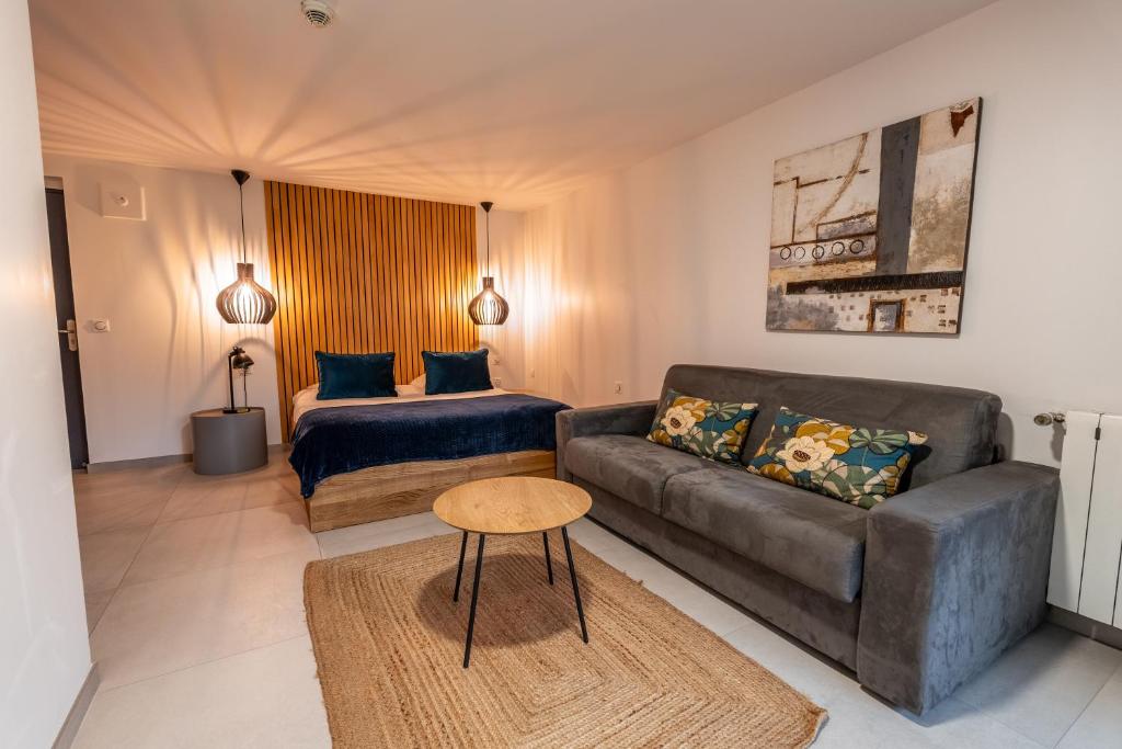 uma sala de estar com um sofá e uma cama em Hôtel Quai des Pontis em Cognac